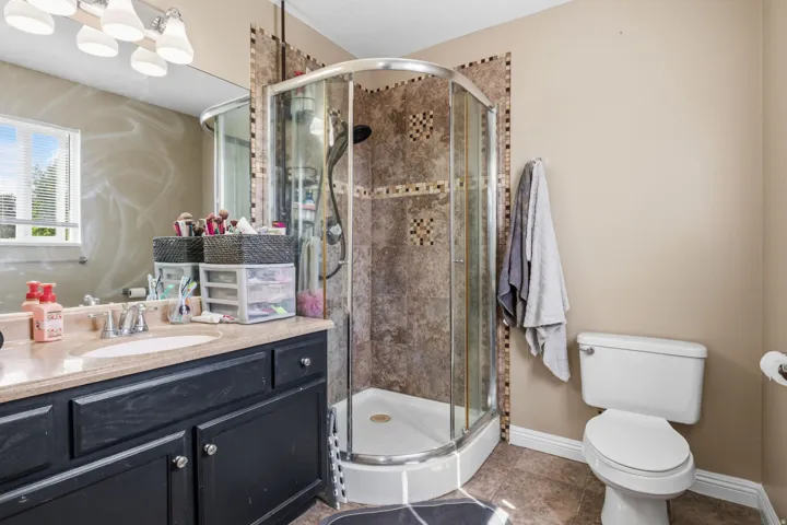 Corner shower enclosure with glass doors and decorative tile surround