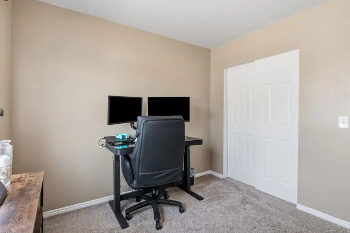 Carpeted flooring, neutral wall tones, white trim, and a bi-fold closet door