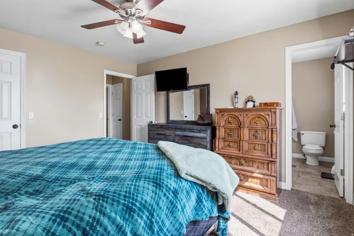 Carpeted flooring with light neutral wall tones, white trim, and a ceiling fan with integrated lighting