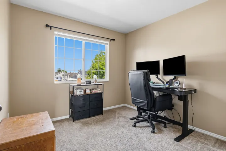 Neutral wall paint, window with grid panes, textured carpet flooring