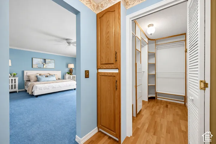 Primary Bedroom Closet with Built-ins and hardwood flooring.