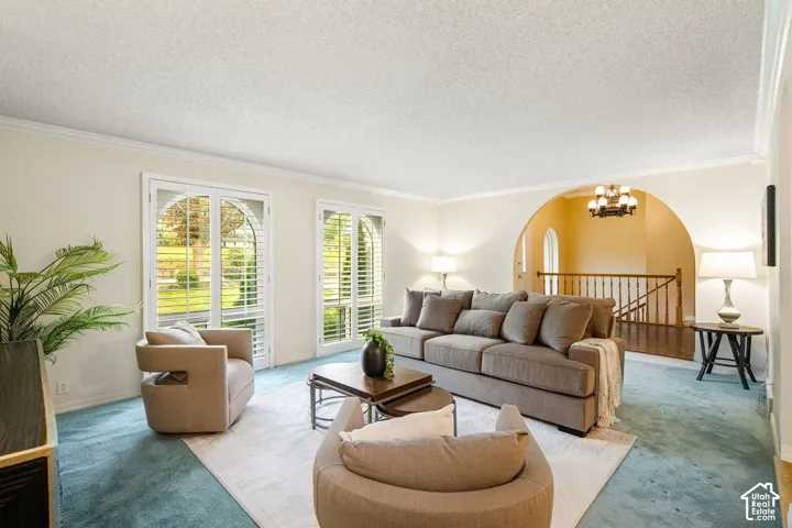 Formal Living Room featuring arches, crown molding, and plantation shutters