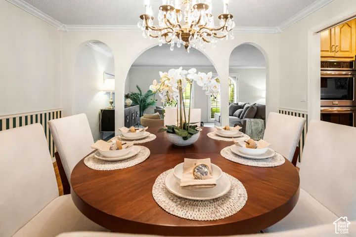 Formal Dining Room with archways, crown molding, chair rail, hardwood floors, and plantation shutters