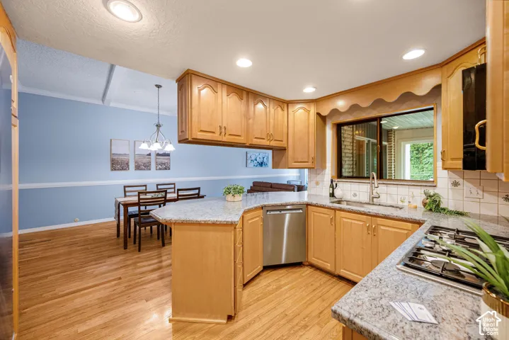 Kitchen featuring light wood cabinetry, stone countertops, a stainless steel dishwasher, a gas cooktop, and a tile backsplash