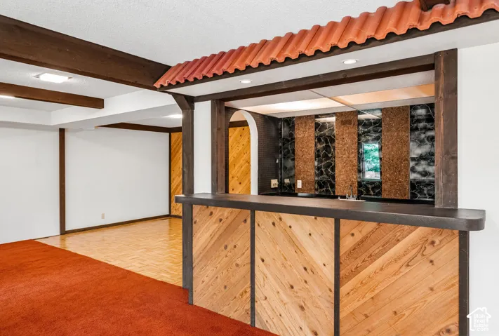 Built-in bar with wood paneling and dark countertop, accented by a distinctive tiled roof overhang