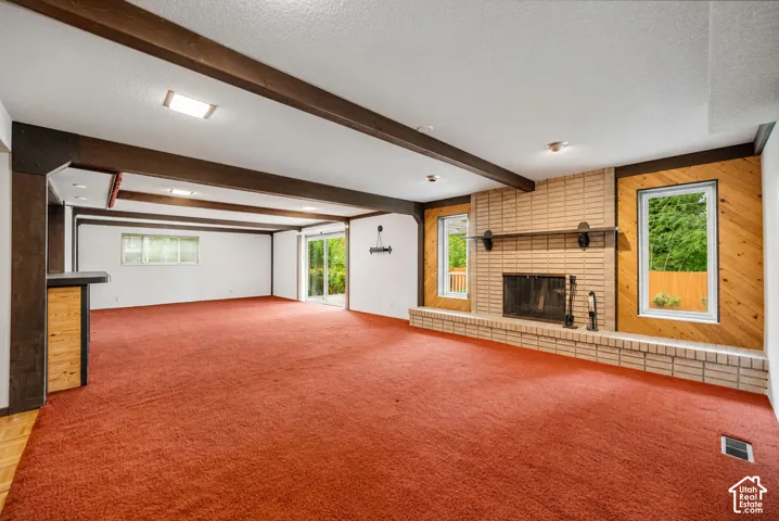 Spacious recreation room with fireplace, wet bar, and covered patio