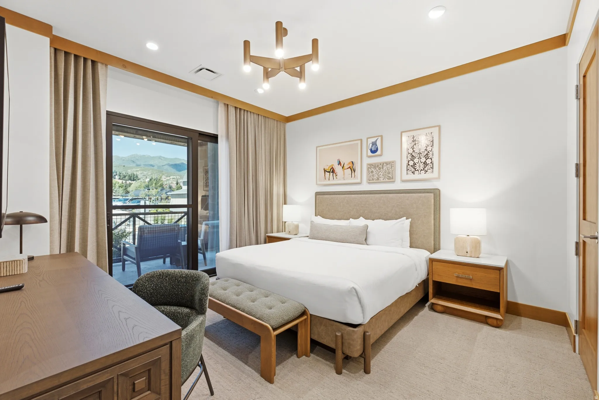 Spacious room with a private balcony, large sliding glass doors, contemporary lighting fixture, and light wood-finish trim and doors