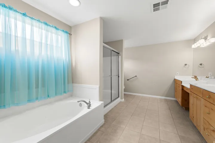 Dual vanity with integrated sinks, wood cabinetry, and overhead lighting
