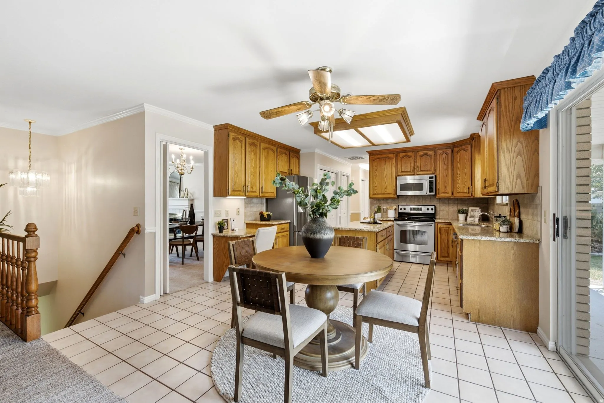 Kitchen featuring wood cabinetry, stainless steel appliances, and light-toned tile flooring