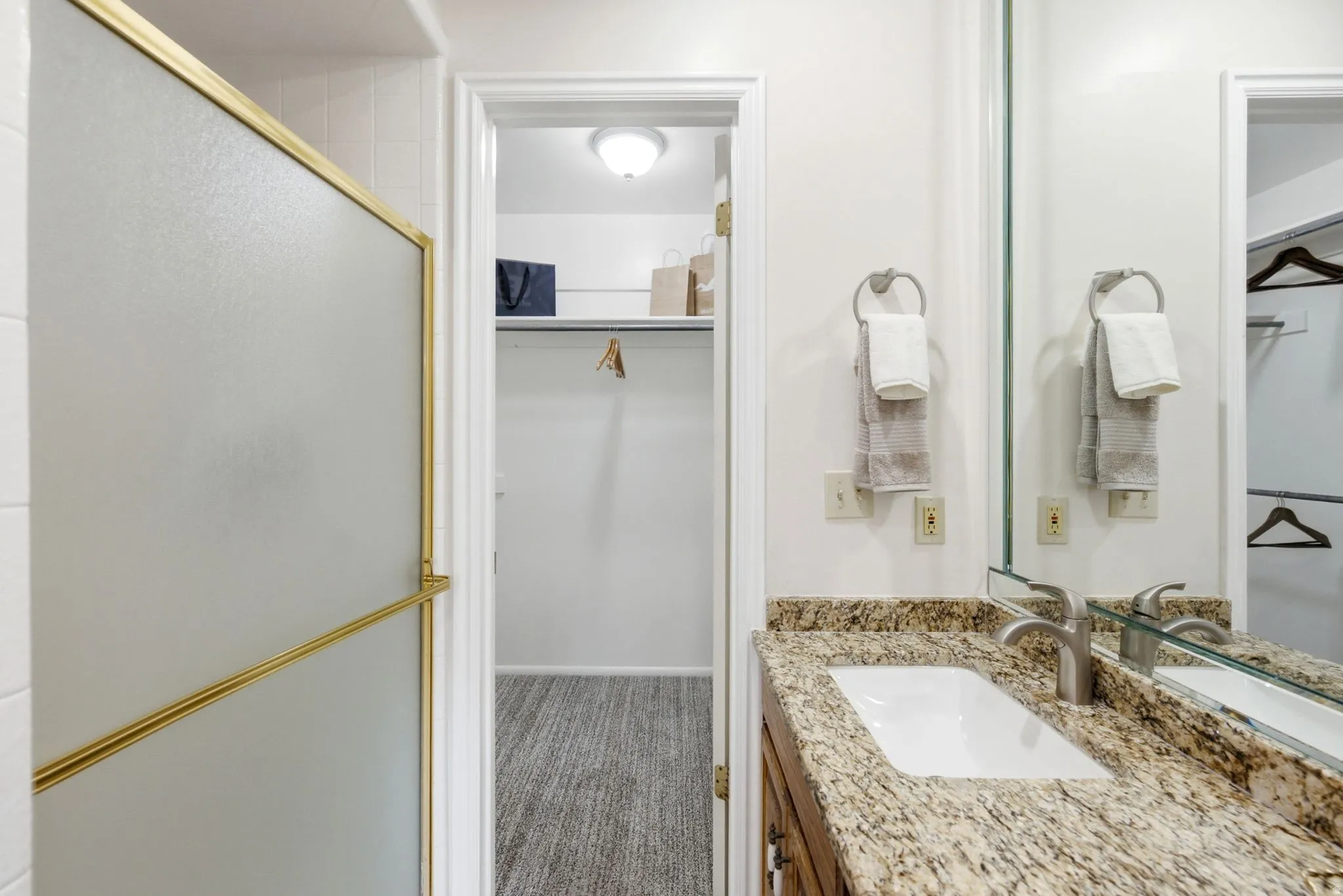 Single vanity with a granite countertop, undermount sink, and brushed nickel faucet