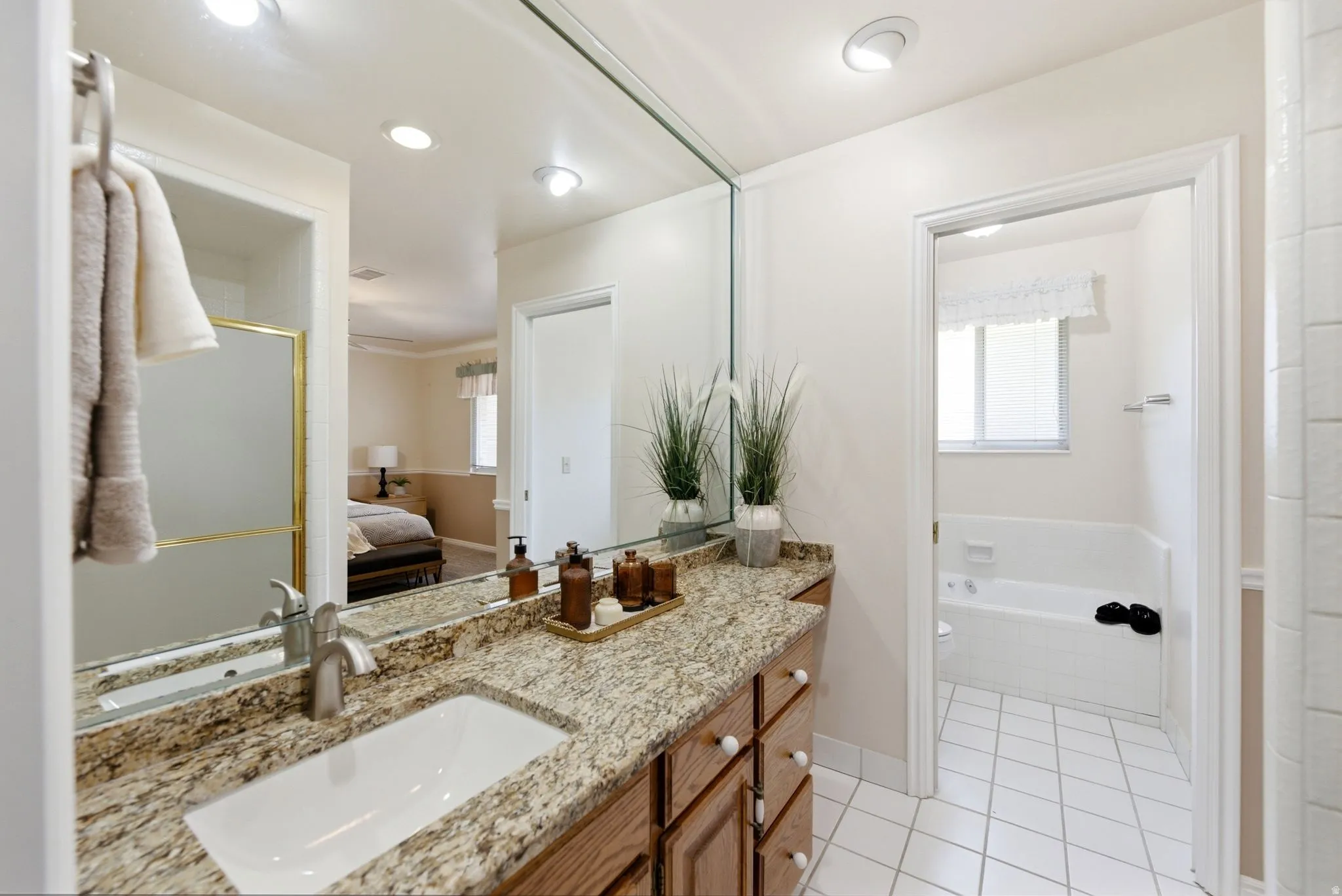 Vanity with a granite countertop, undermount sink, and brushed nickel faucet
