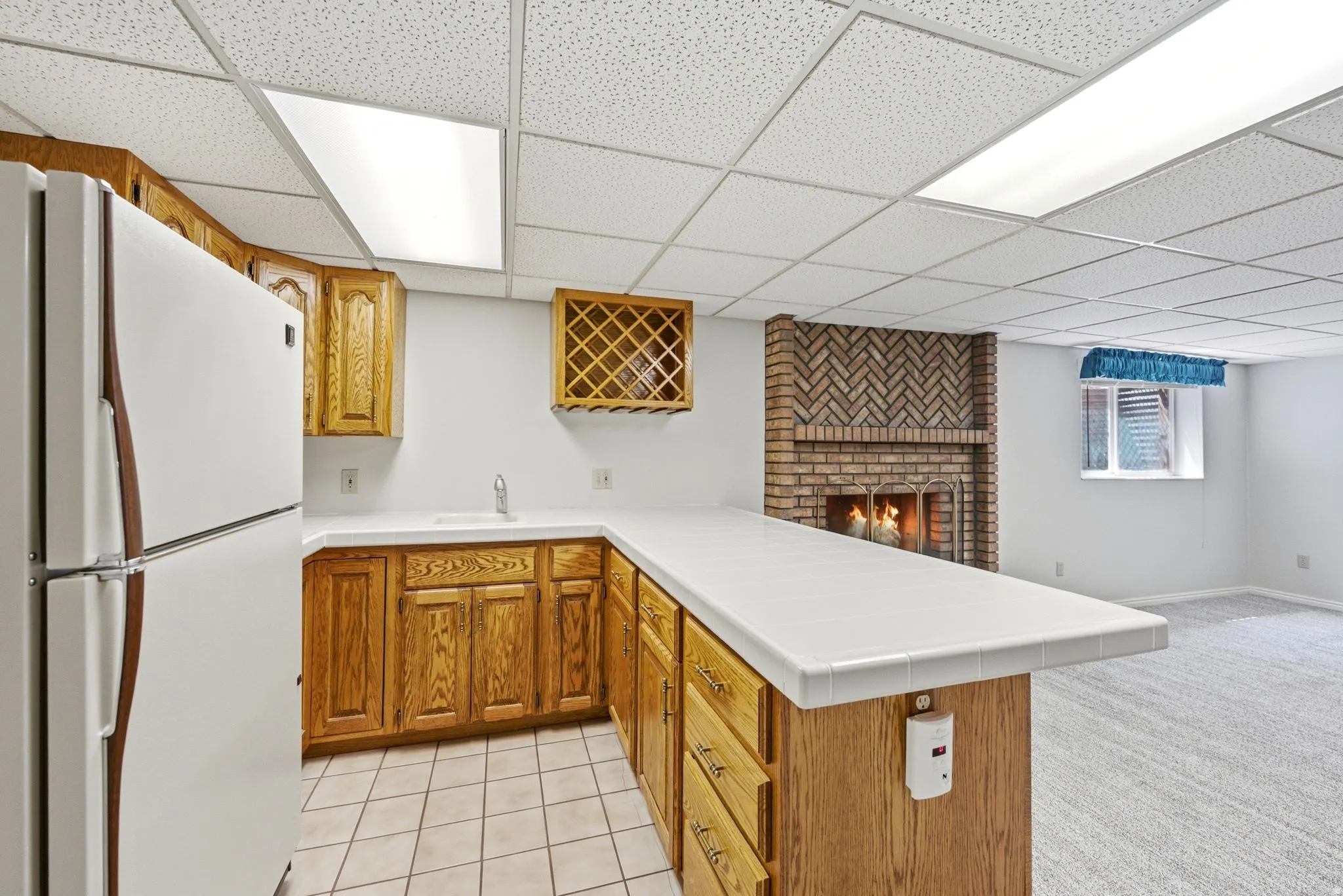 Wet bar with wood cabinetry, solid surface countertop, and tile flooring