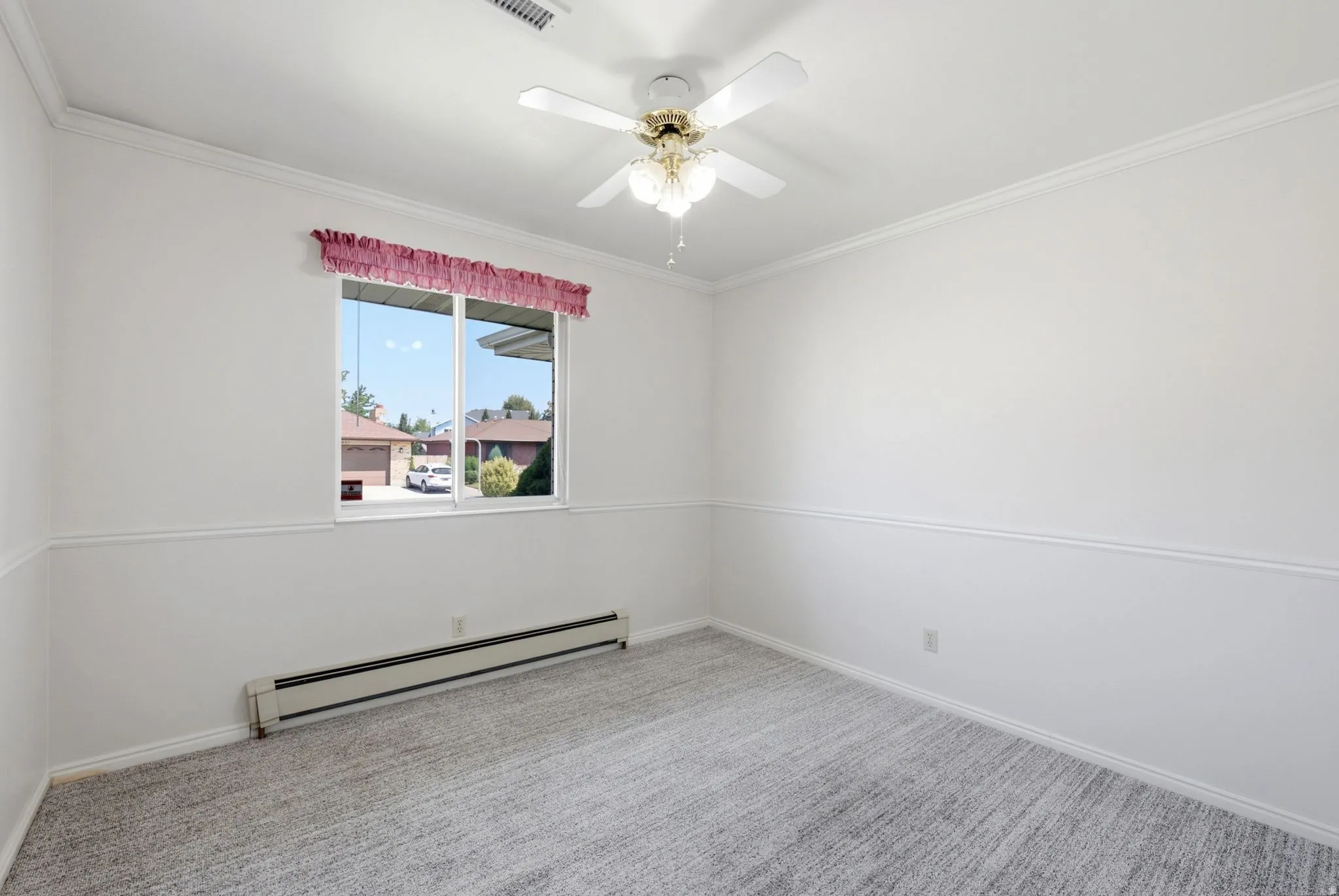 White walls with chair rail molding and crown molding, ceiling fan with light fixture, and window with a window unit