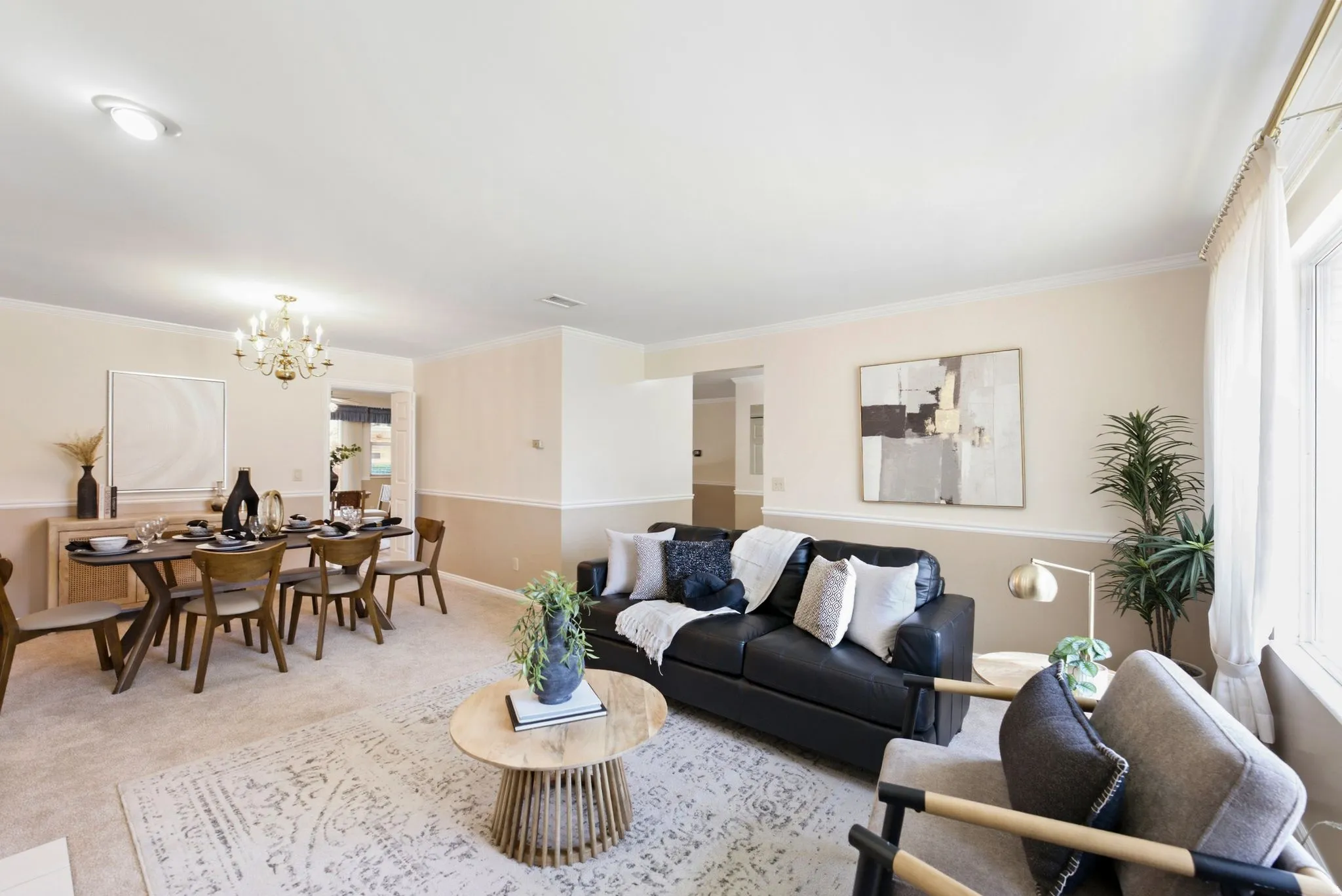 Recessed ceiling lighting, crown molding, and a brass chandelier