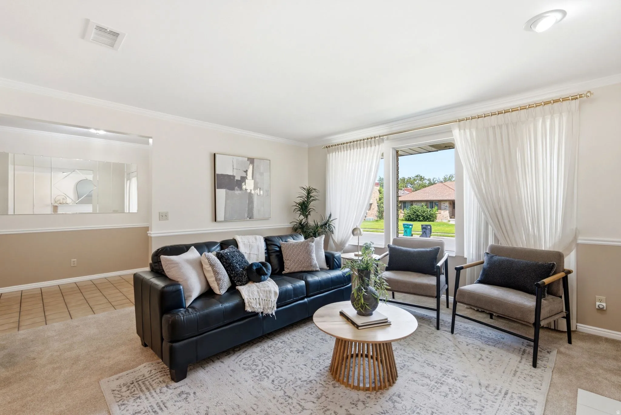 Spacious living area featuring a large picture window, crown molding, and recessed lighting