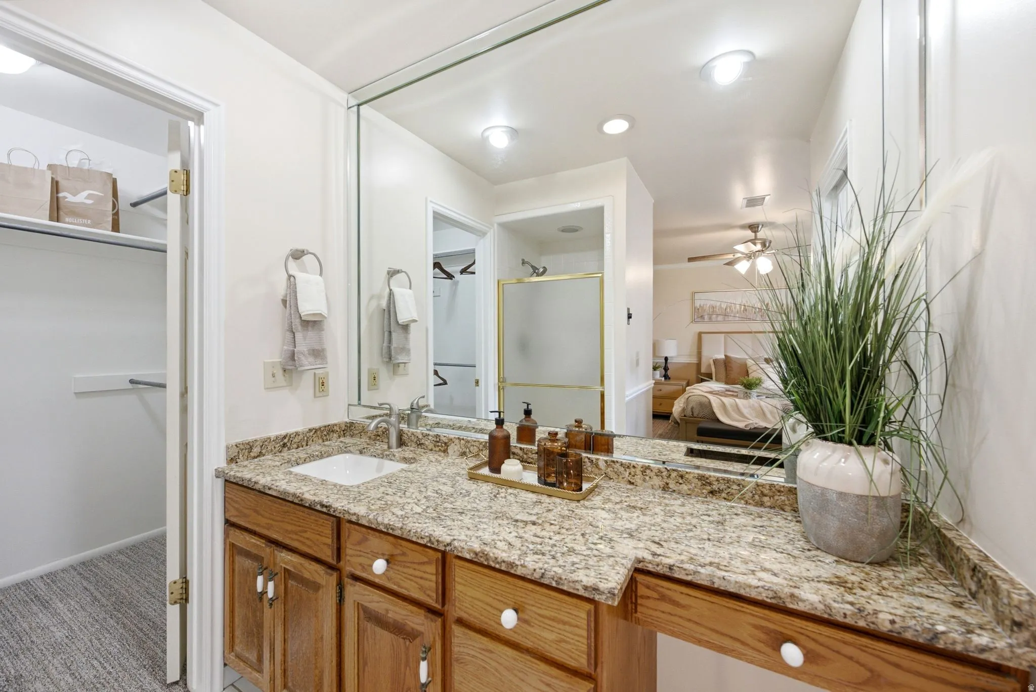 Vanity with stone-finish countertop, undermount sink, and wood-finish cabinetry