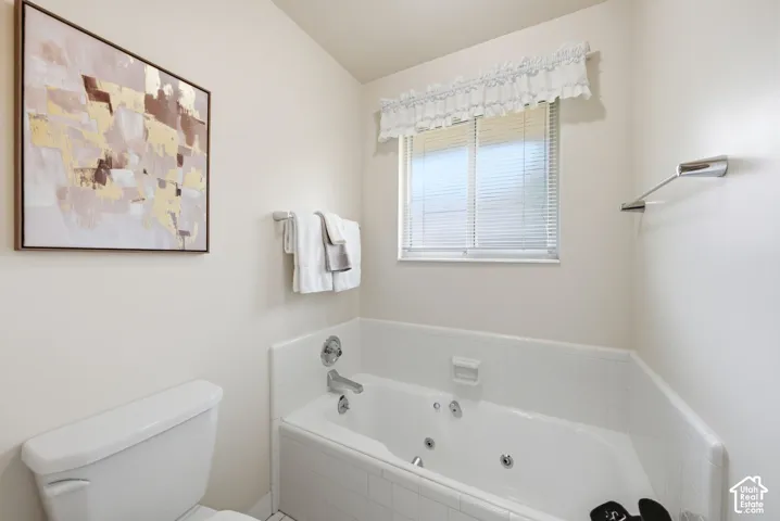Soaking tub with jetted features and  white ceramic tile surround