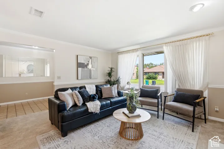 Spacious living area featuring a large picture window, crown molding, and recessed lighting
