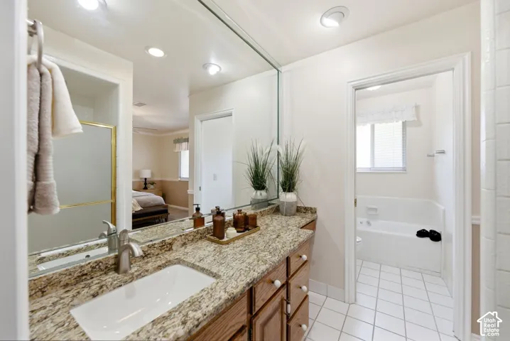 Vanity with a granite countertop, undermount sink, and brushed nickel faucet