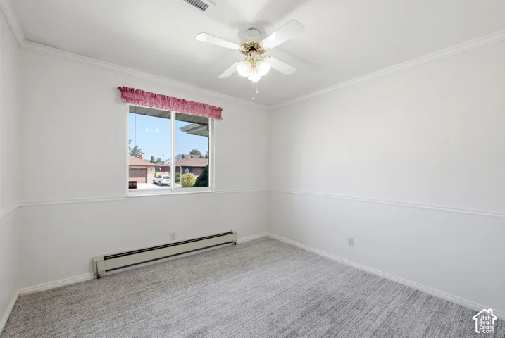 White walls with chair rail molding and crown molding, and ceiling fan with light fixture
