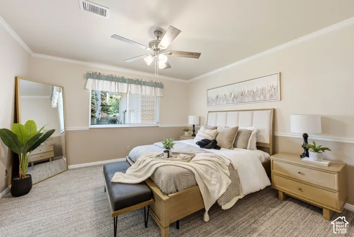 Carpeted room featuring crown molding, chair rail detailing, a window, and a ceiling fan with integrated lighting