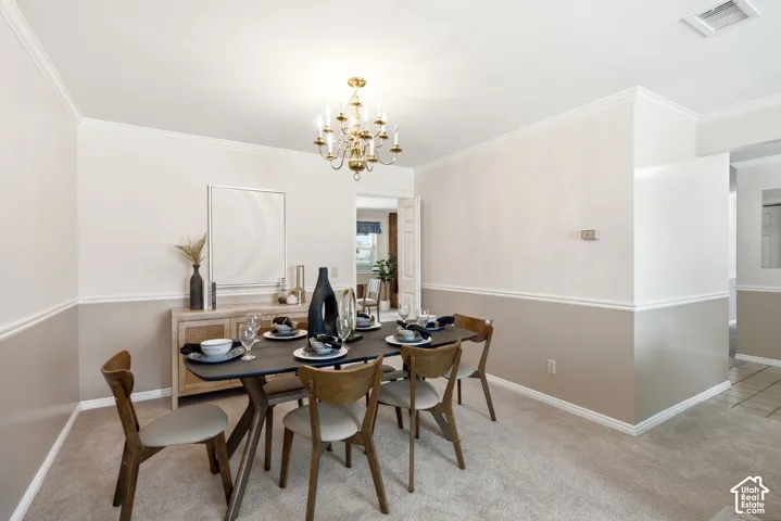 Dining area featuring crown molding, two-tone wall treatment, and carpet flooring