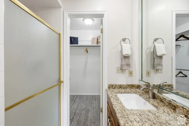 Single vanity with a granite countertop, undermount sink, and brushed nickel faucet
