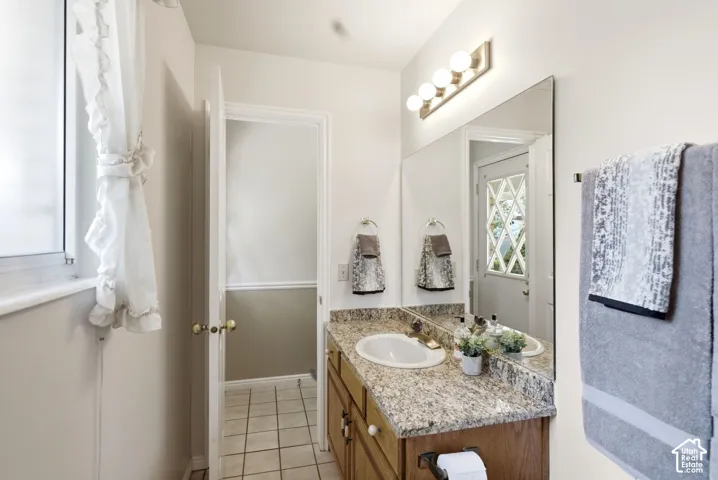 Bathroom vanity featuring a granite countertop and undermount sink.