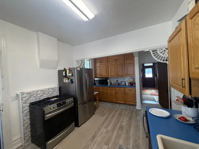 Kitchen featuring wood-finish flooring, stainless steel appliances, and wood cabinetry