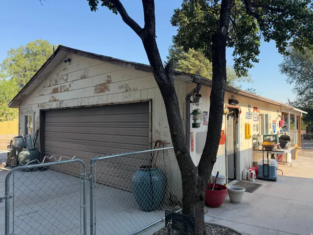 Detached garage with a roll-up door and an adjacent covered patio area