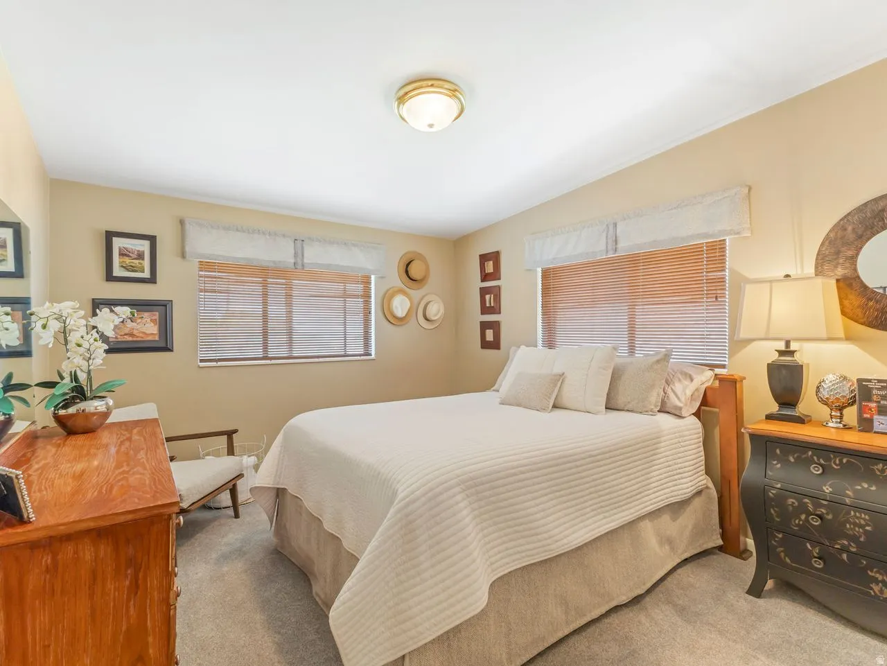 Recessed lighting, warm neutral wall tones, two windows with blinds, and carpeted flooring