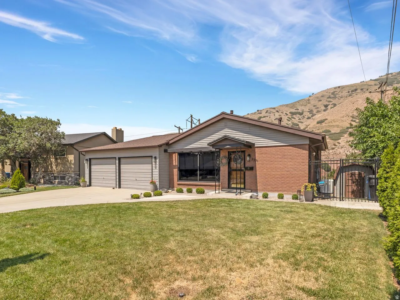 Brick and siding exterior with a covered entry, two-car garage, and a fenced side yard