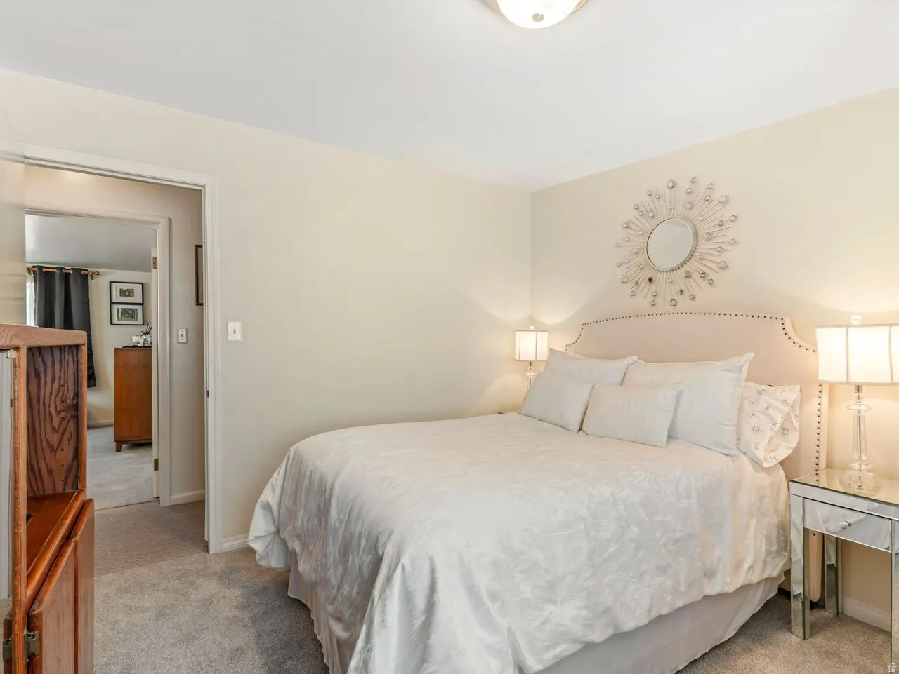 Neutral wall tones, plush carpet flooring, and a flush mount ceiling light