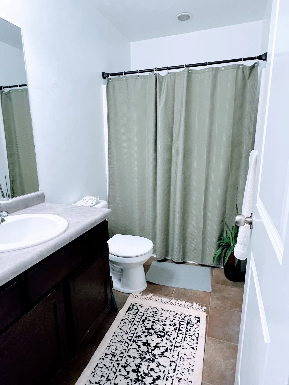 Bathroom featuring a dark wood-finish vanity, recessed ceiling lighting, tiled flooring, and a shower/tub combination