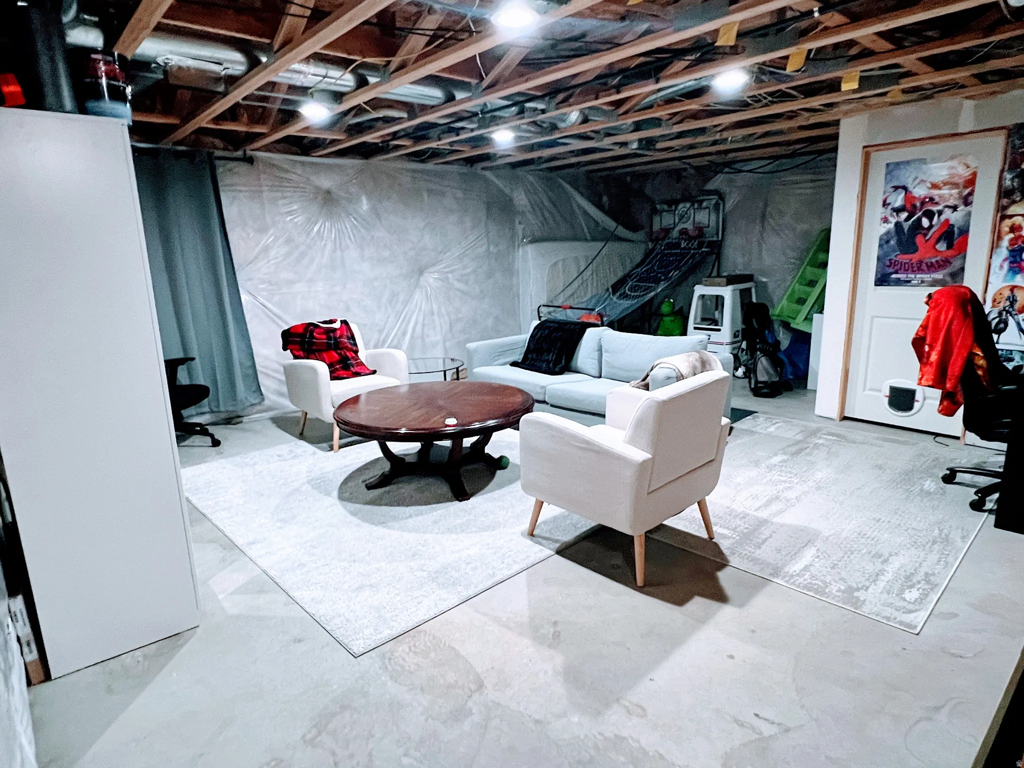 Unfinished basement space featuring exposed ceiling joists and concrete flooring