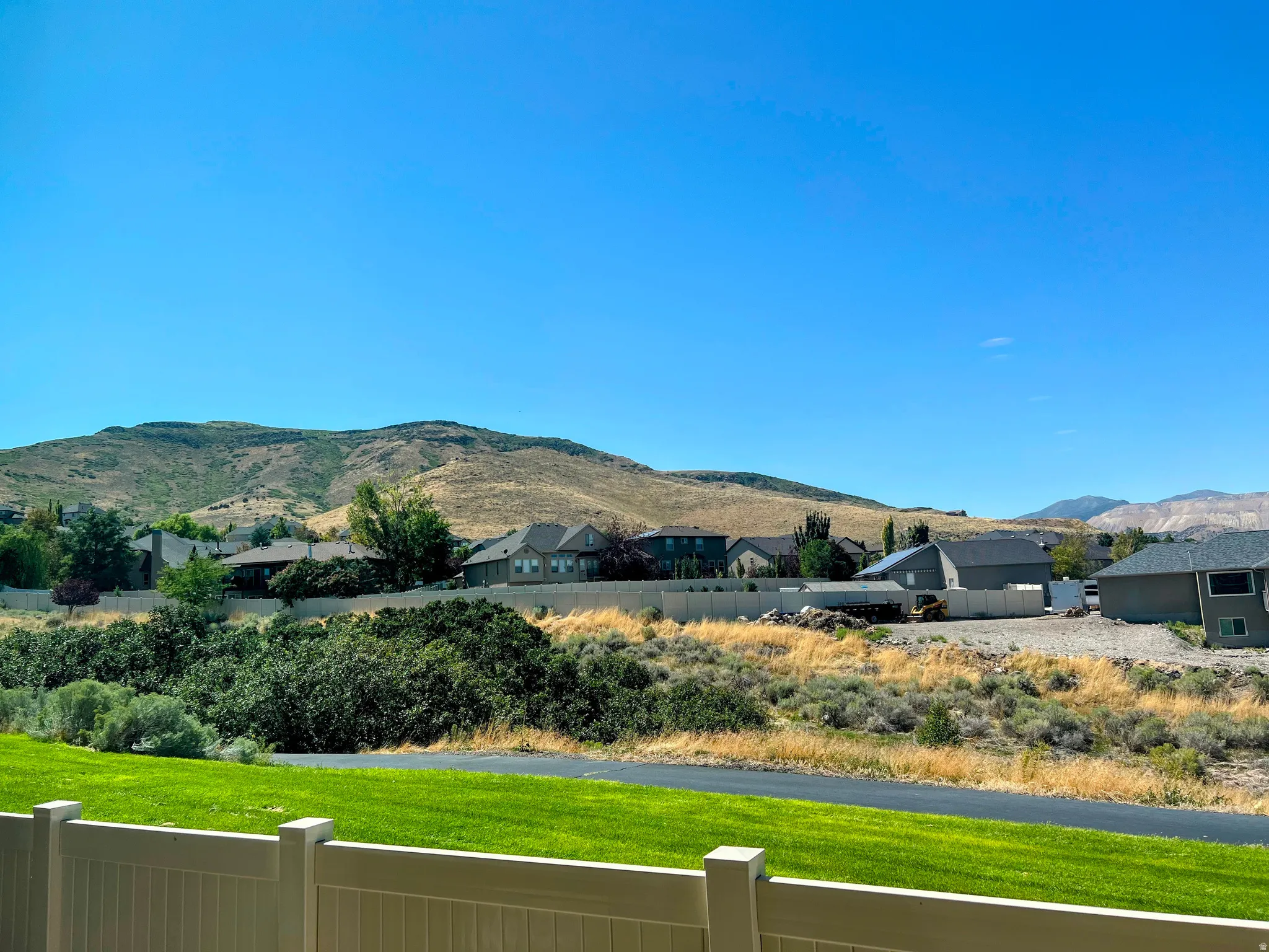 Expansive mountain backdrop with a vibrant green lawn foreground
