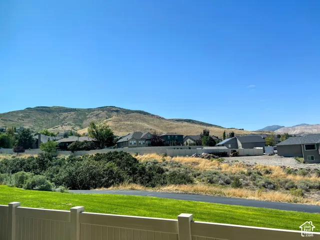 Expansive mountain backdrop with a vibrant green lawn foreground