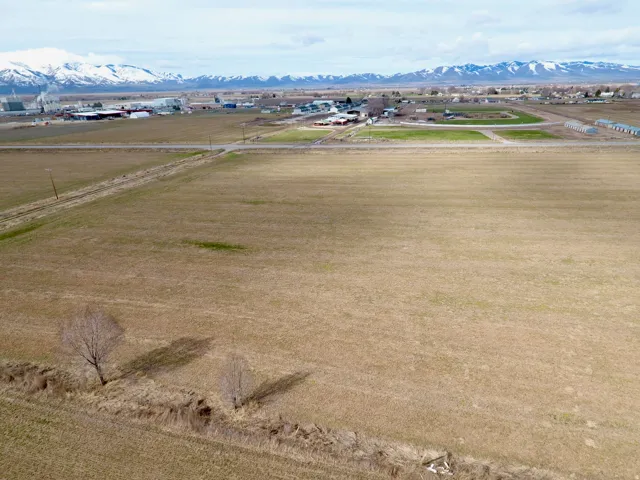 Expansive open field with distant snow-capped mountains