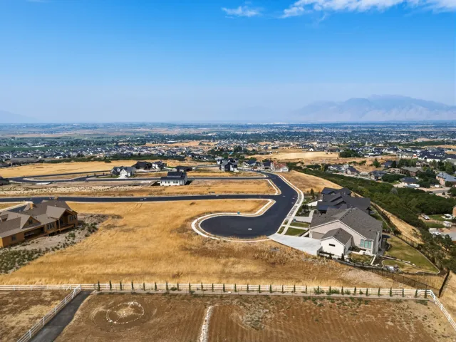 Expansive undeveloped land with distant mountain ranges and scattered residential properties