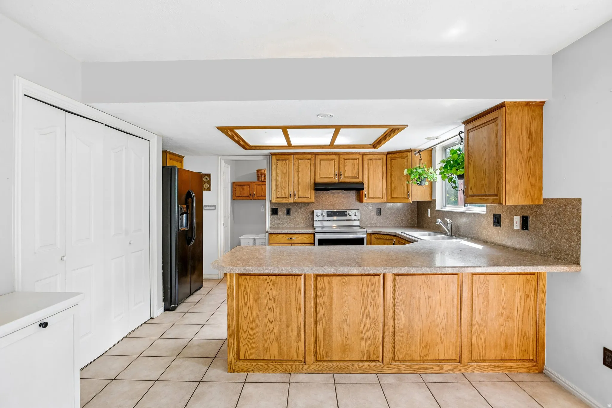 Kitchen featuring wood-finish cabinetry, tile flooring, a breakfast bar, and a double-door pantry