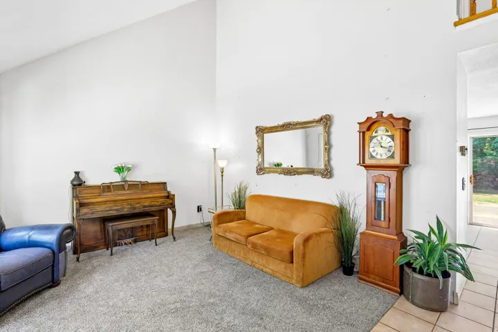 Vaulted ceiling, carpeted flooring, and tiled entryway