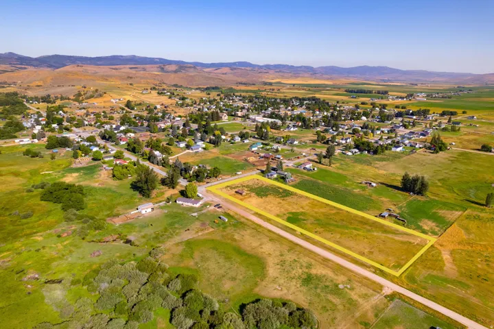 Expansive land parcel featuring open fields and direct road frontage