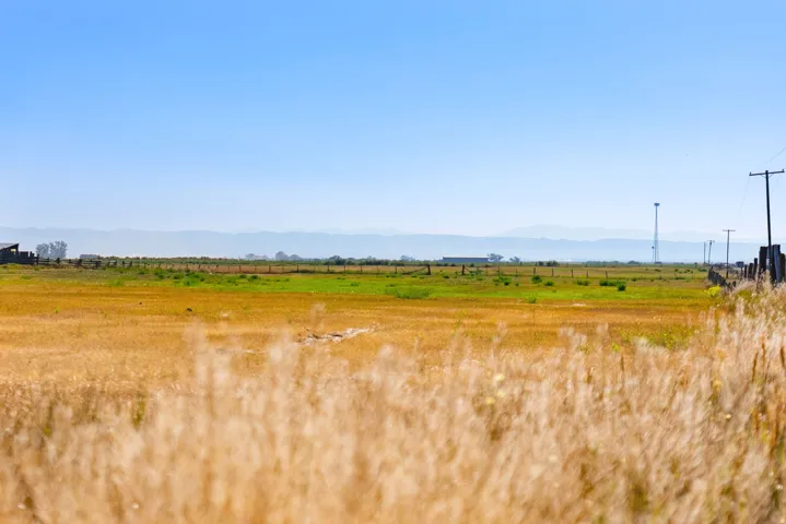 Expansive open fields with distant mountains and a clear sky