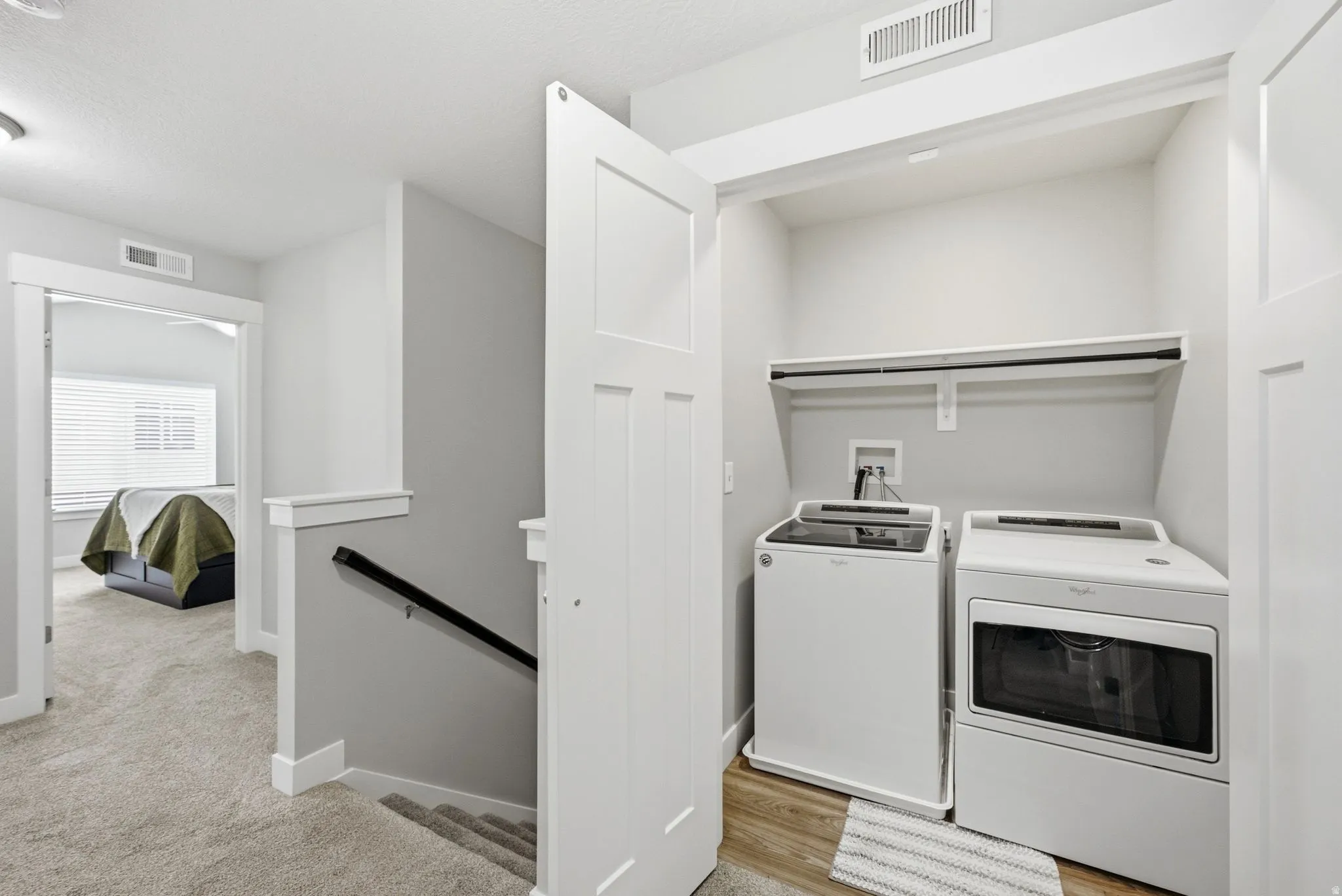 Dedicated laundry closet with wood-finish flooring and an integrated shelving unit