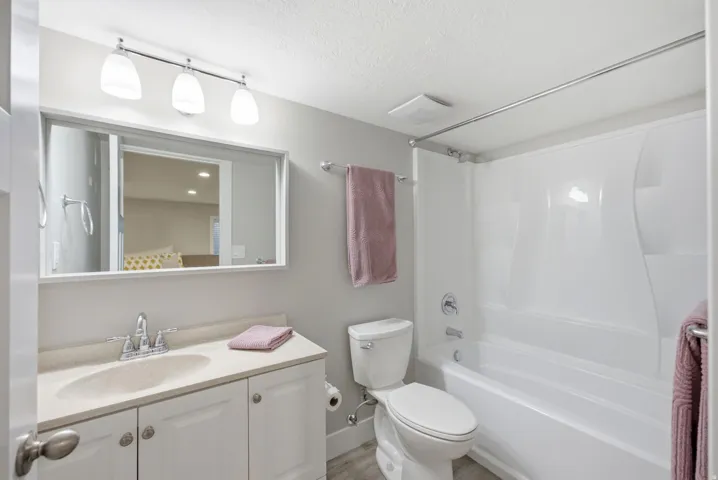 White vanity with integrated sink, chrome faucet, and overhead lighting