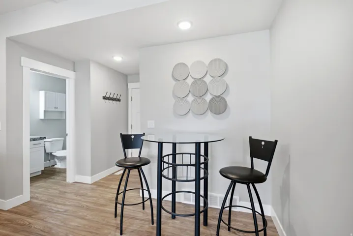 Wood-finish flooring, recessed lighting, and a wall-mounted coat rack
