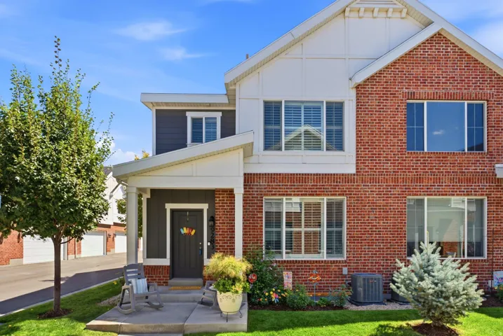 Brick and siding exterior, columned front porch, established landscaping, multiple windows with shutters, and a well-maintained lawn