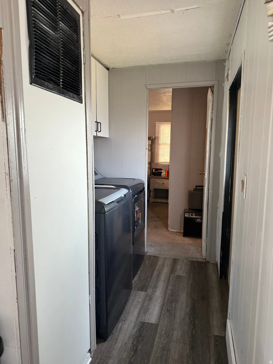 Wood-finish flooring with white paneled walls and built-in white cabinetry