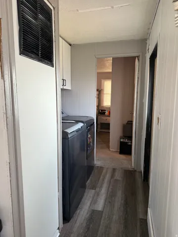 Wood-finish flooring with white paneled walls and built-in white cabinetry