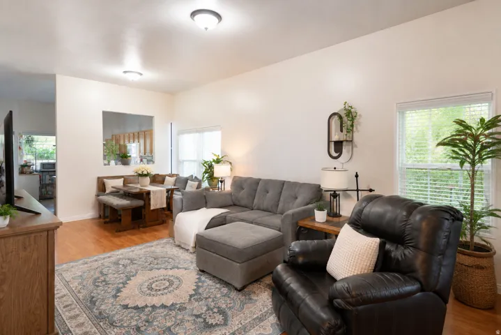 Recessed lighting illuminates the living area featuring wood-finish flooring